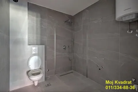 Moderno kupatilo obloženo sivim pločicama sa tuš kabinom i toaletom. - image 5