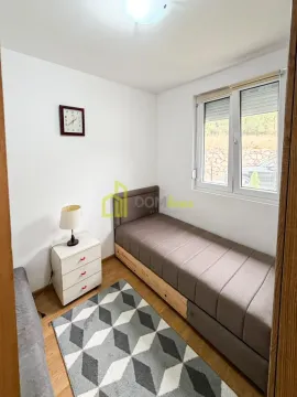Smaller bedroom with a pull-out bed and a nightstand. - image 9