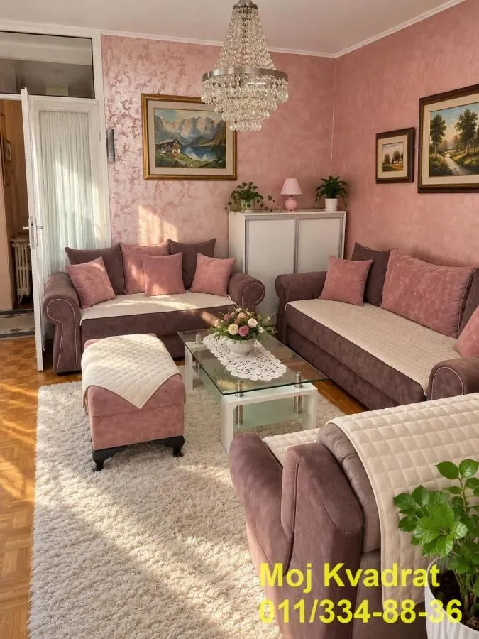 Living room with a sofa set, coffee table, and paintings on the wall.