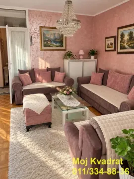 Living room with a sofa set, coffee table, and paintings on the wall. - image 3