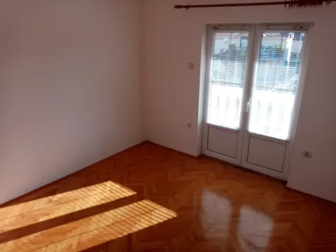 Empty room with parquet flooring and balcony doors. - image 23