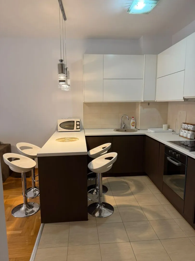 Modern kitchen with a breakfast bar and built-in appliances.
