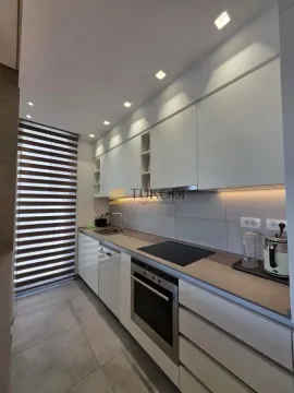 Modern white kitchen with built-in appliances. - image 10
