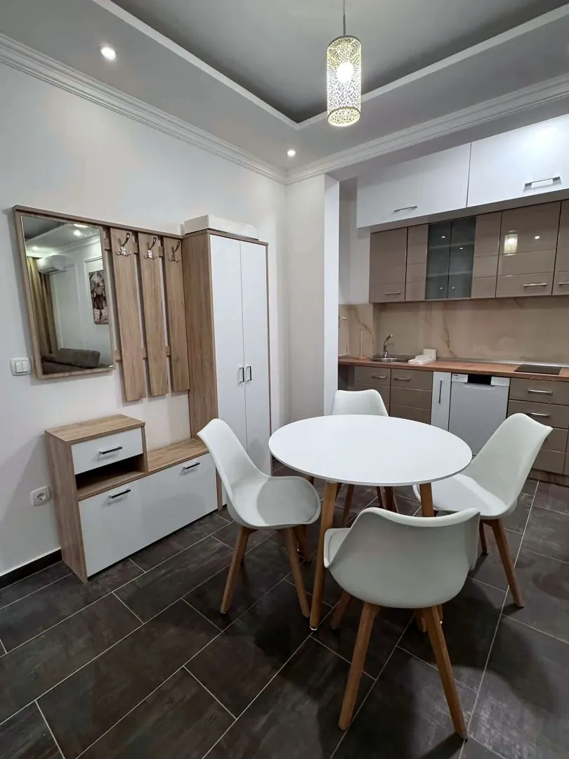 Dining area with a round table and built-in kitchen units.