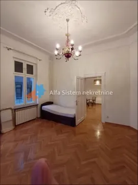 Bedroom with a bed, hardwood parquet flooring, and an ornamental chandelier. - image 2