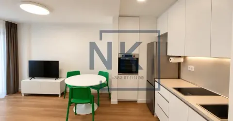Moderna kuhinja sa bijelim elementima, trpezarijskim stolom i zelenim stolicama. - image 11