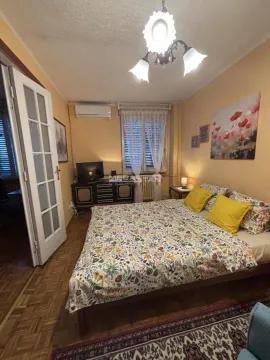 Furnished bedroom with a double bed, dresser, and air conditioning unit. - image 3