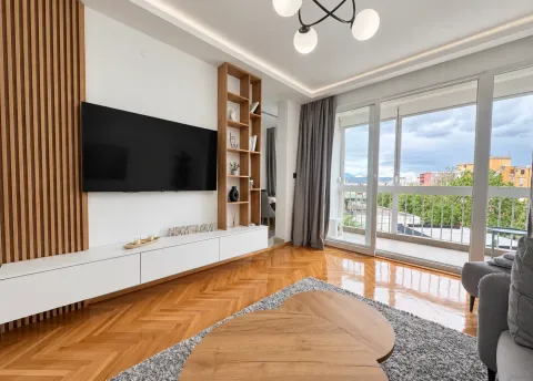 Modern living room with a TV unit, wooden wall panels, and access to the terrace. - image 2