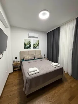 Uređena spavaća soba sa bračnim krevetom i zavesama. - image 4