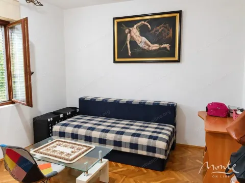 Manja dnevna soba sa kaučem, stočićem i slikom na zidu. - image 14