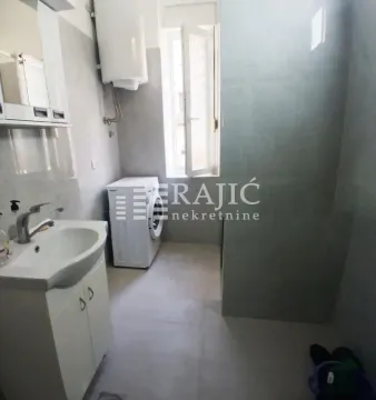 View of the bathroom with a sink and washing machine. - image 6