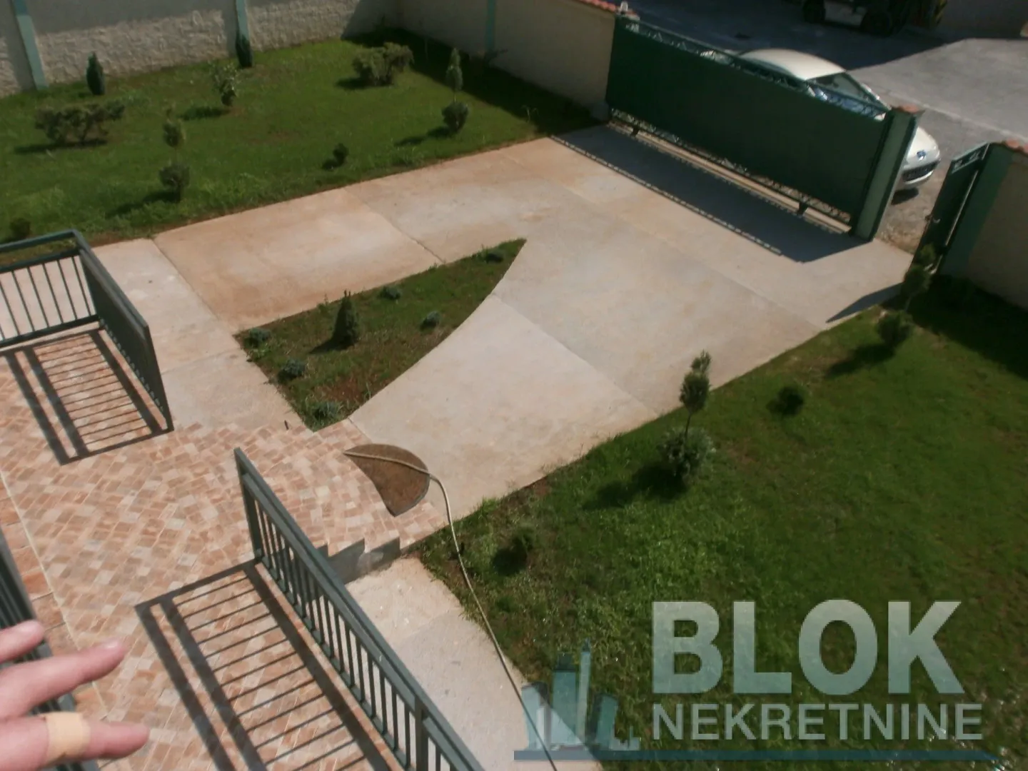 View from the terrace of the landscaped yard and driveway.