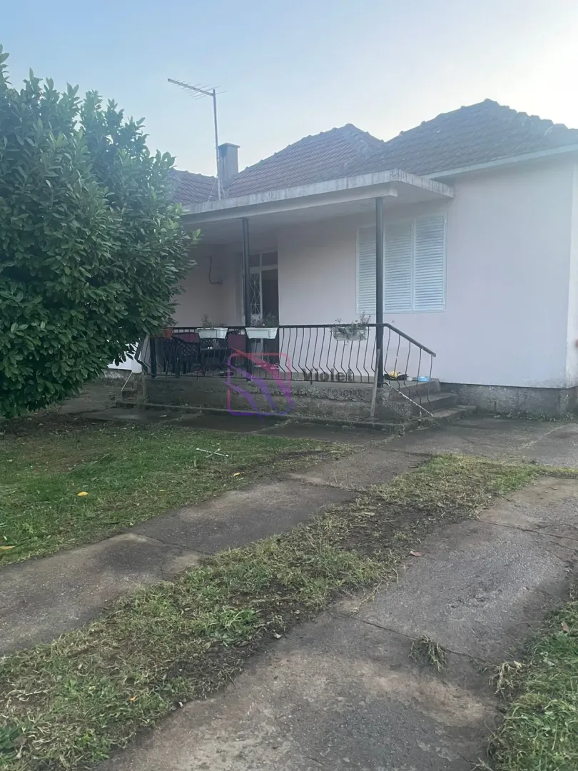 Pogled na spoljašnjost kuće sa dvorištem i terasom.