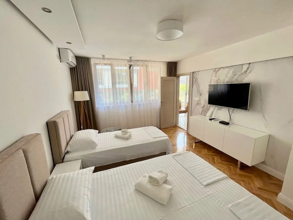 Spacious bedroom with two beds and a TV.