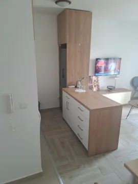 Smaller kitchen with wooden elements and an island. - image 9