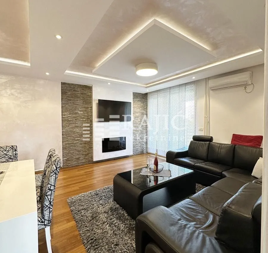 Spacious and bright living room with a sofa and modern ceiling.
