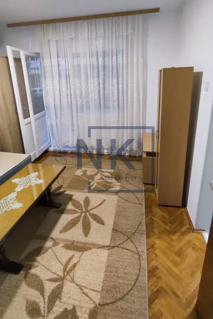 Living room with parquet flooring, rug and wooden furniture.