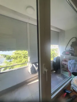 Zastakljeni balkon sa roletnama i pogledom na zelenilo. - image 8