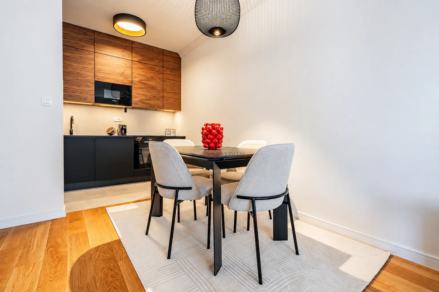 Dining area with a modern table and chairs situated next to the kitchen.