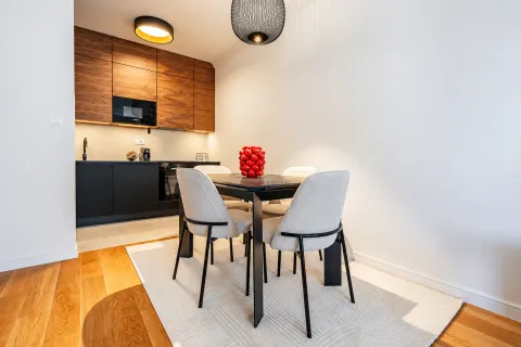 Dining area with a modern table and chairs situated next to the kitchen. - image 5