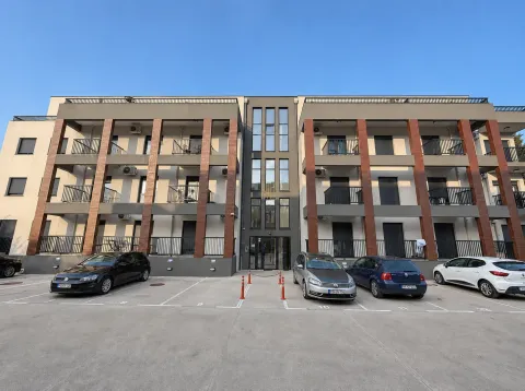 Pogled na spoljašnjost stambene zgrade sa parkingom i balkonima. - image 12