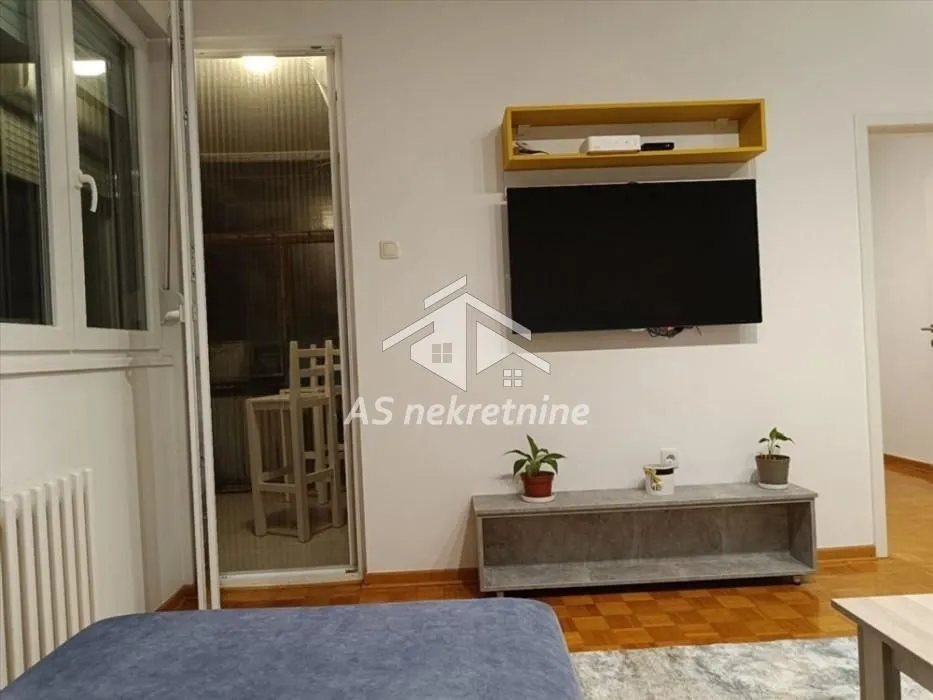 View of the living room with a wall-mounted TV and access to the terrace.