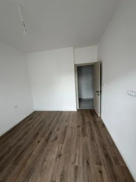 Empty room with wood-look flooring and white walls. - image 5