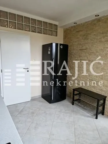 Part of the kitchen with a refrigerator and a shoe rack.