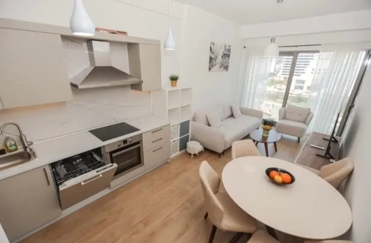 Living room with dining area and kitchen in light tones.
