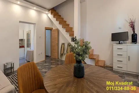 Living room with a dining table and stairs leading to the upper floor. - image 15