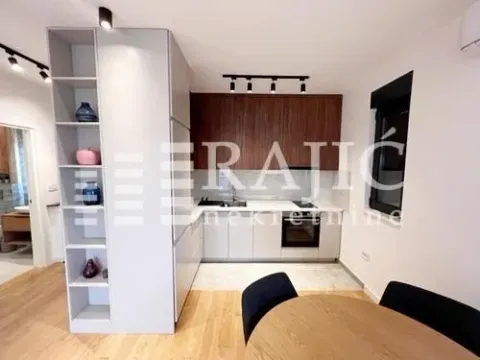 Modern kitchen with white units and a dining table. - image 5