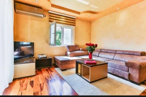 Living room with a corner sofa, television and air conditioning unit. - image 15