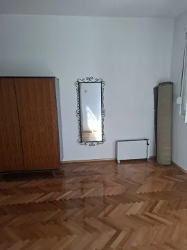Polunamještena soba sa drvenim ormarom, ogledalom i parketom. - image 7