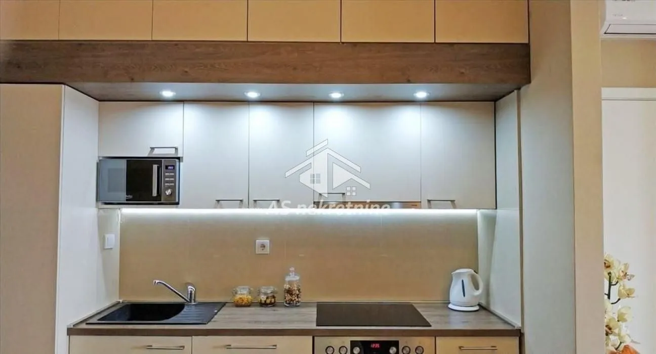 Modern kitchen with built-in units and lighting.