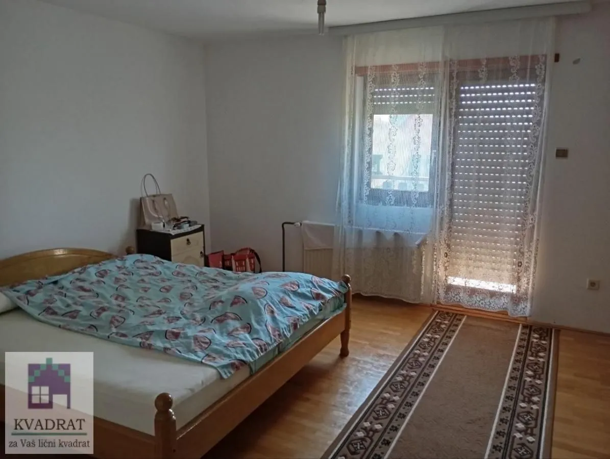 Spavaća soba sa bračnim krevetom i izlazom na terasu.