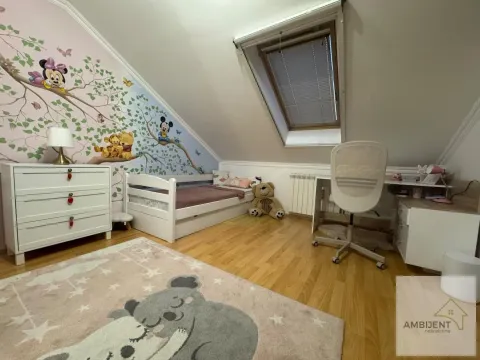 Dečja soba u potkrovlju sa krevetom, radnim stolom i tapetom sa motivima crtanih filmova. - image 9