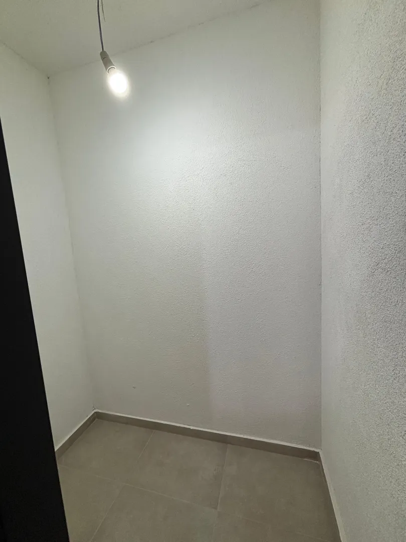 Prazna prostorija sa bijelim zidovima i osvjetljenjem na plafonu.