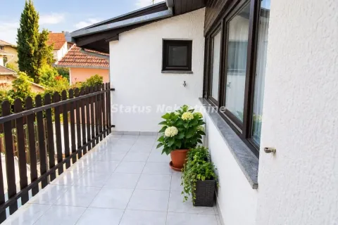 Natkriveni balkon sa popločanim podom, drvenom ogradom i ukrasnim saksijama. - image 10