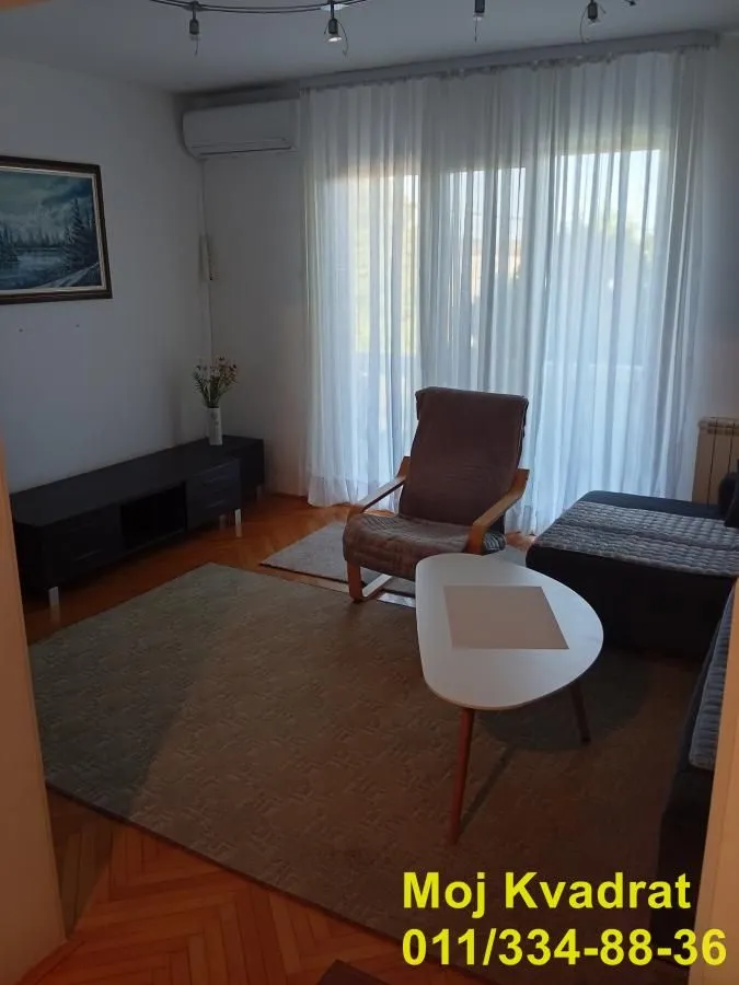 Living room with a sofa set, armchair, and TV unit.
