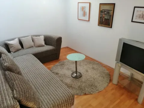 Living room with a corner sofa, a small table and a TV. - image 2