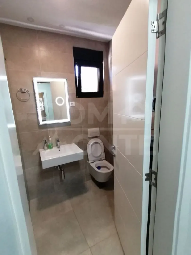 View of a modern bathroom with a sink and toilet.