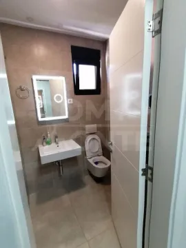 View of a modern bathroom with a sink and toilet. - image 7