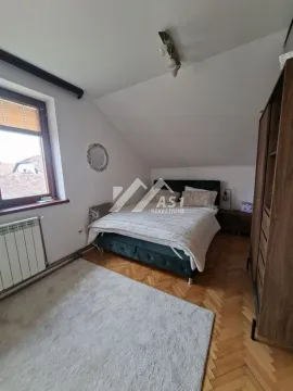 Nameštena spavaća soba sa bračnim krevetom, ormarom i krovnim kosinama. - image 5