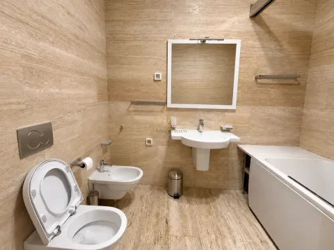 Kupatilo opremljeno umivaonikom, WC šoljom, bideom i kadom, obloženo keramičkim pločicama u boji drveta. - image 16