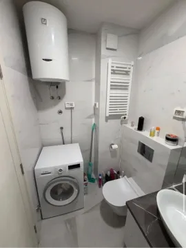 Manje kupatilo sa veš mašinom, bojlerom i sanitarijama obloženo mermernim pločicama. - image 5