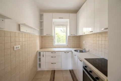 Small white kitchen with a built-in hob and sink. - image 7