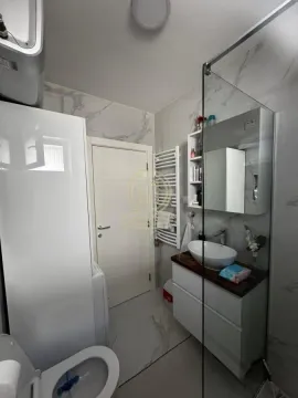 Savremeno opremljeno kupatilo sa umivaonikom, tuš kabinom i belim sanitarijama. - image 11