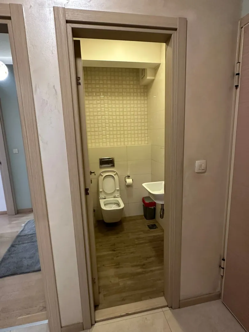 Pogled kroz vrata na uređeno kupatilo sa toaletom i umivaonikom.