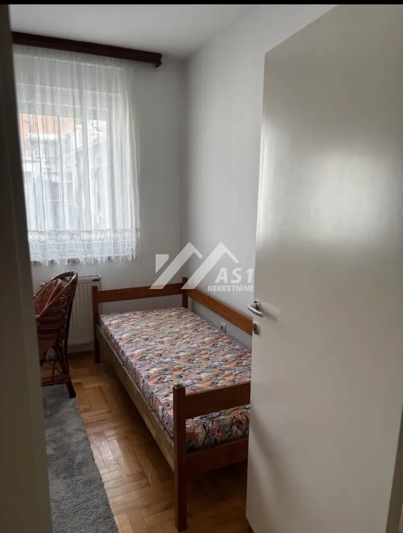 Smaller bedroom with a bed and a window.
