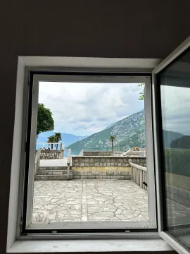 View through the window towards the courtyard, sea, and mountains. - image 9